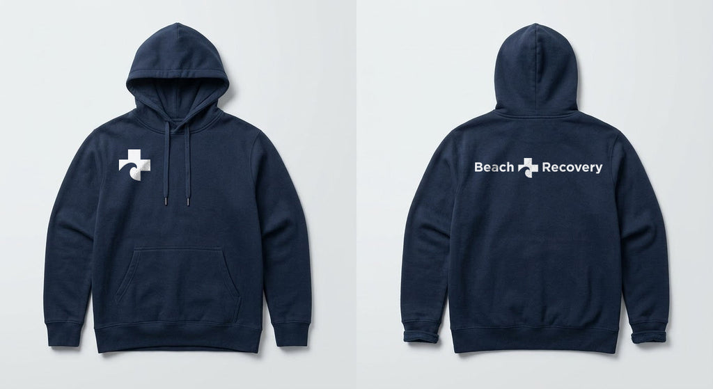 Navy hoodie front and back: Cross symbol at the right chest, full Beach Recovery signature across the back.