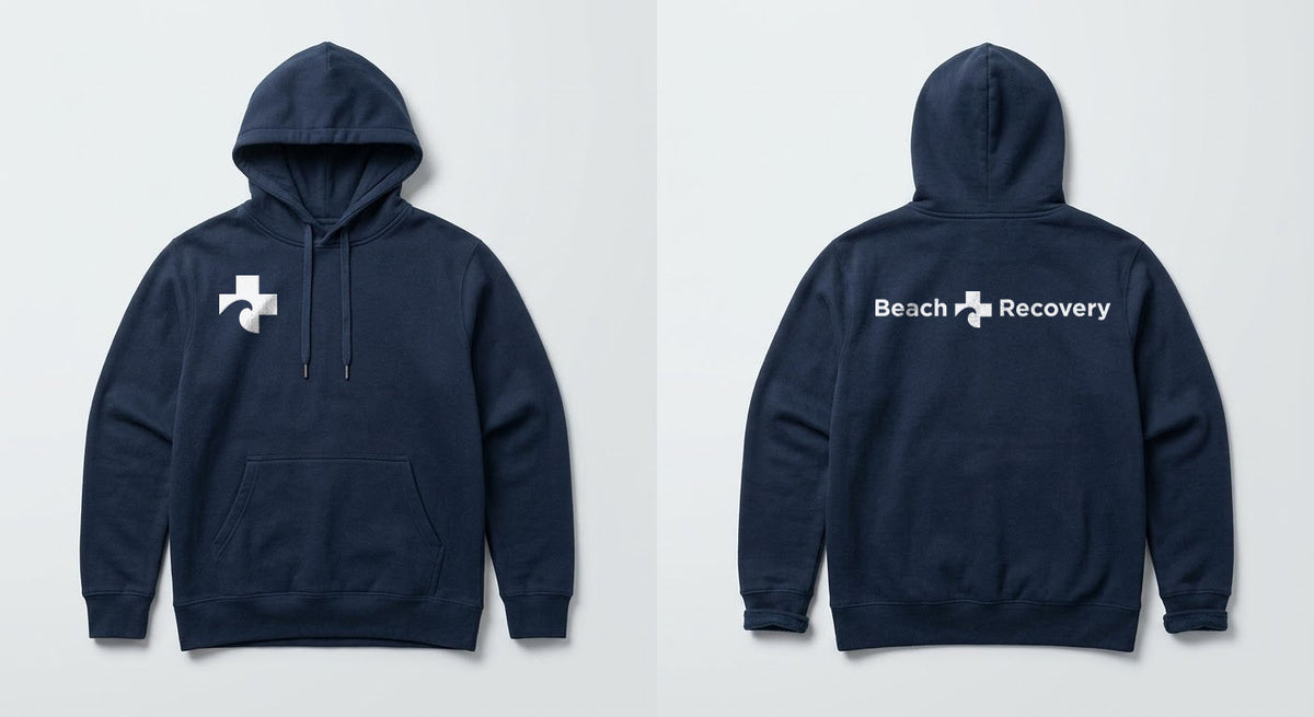 Navy hoodie front and back: Cross symbol at the right chest, full Beach Recovery signature across the back.