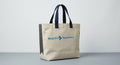 Natural canvas tote with navy webbing handles and the full Beach Recovery signature printed in blue across the face.